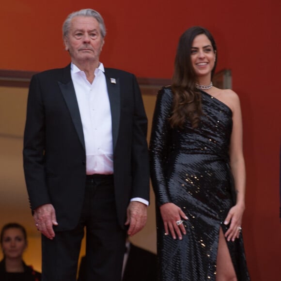 Alain Delon (Palme d'Or d'Honneur du 72ème festival de Cannes avec un badge Paris Match d'une ancienne couverture du magazine titrant "Alain Delon, mes deux amours, Rosalie et Anouchka) et sa fille Anouchka (Robe Elie Saab) - Montée des marches du film "A Hidden Life" lors du 72ème Festival International du Film de Cannes. Le 19 mai 2019 