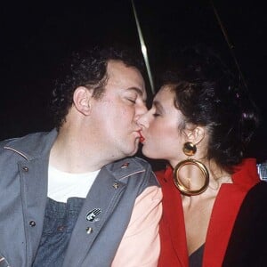 Coluche et une amie fêtent la sortie de l'album de Carlos Sotto en 1985. 