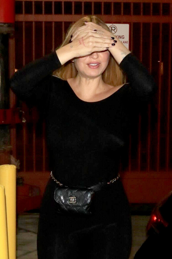Sia se cache des photographes à la sortie du restaurant APL à Hollywood, le 14 août 2018.