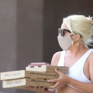 Exclusif - Lady Gaga et son compagnon Michael Polansky, munis de masques de protection contre le coronavirus (Covid-19), quittent un restaurant italien de Malibu les bras chargés de victuailles. Auparavant, le couple avait acheté du vin. Des rumeurs de mariage prochain entre l'homme d'affaires et la chanteuse circulent depuis le confinement lié au virus. Le 14 juin 2020.