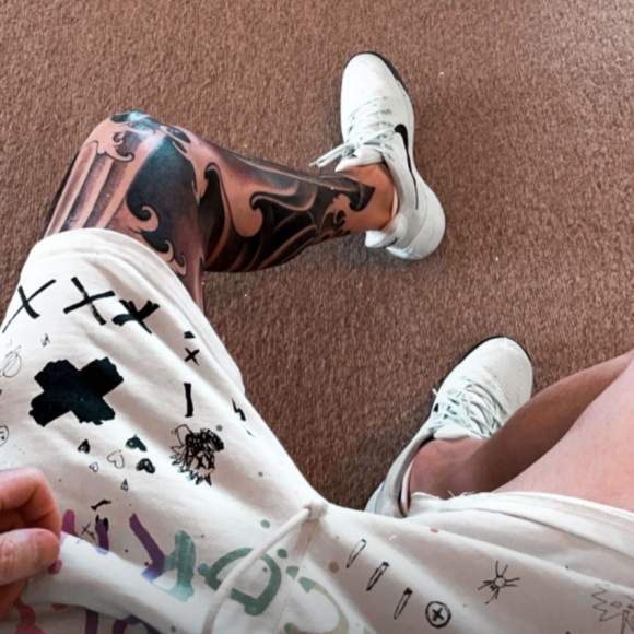 Adam Levine montre son nouveau tatouage à la jambe gauche, réalisé par l'artiste Nathan Kostechko.