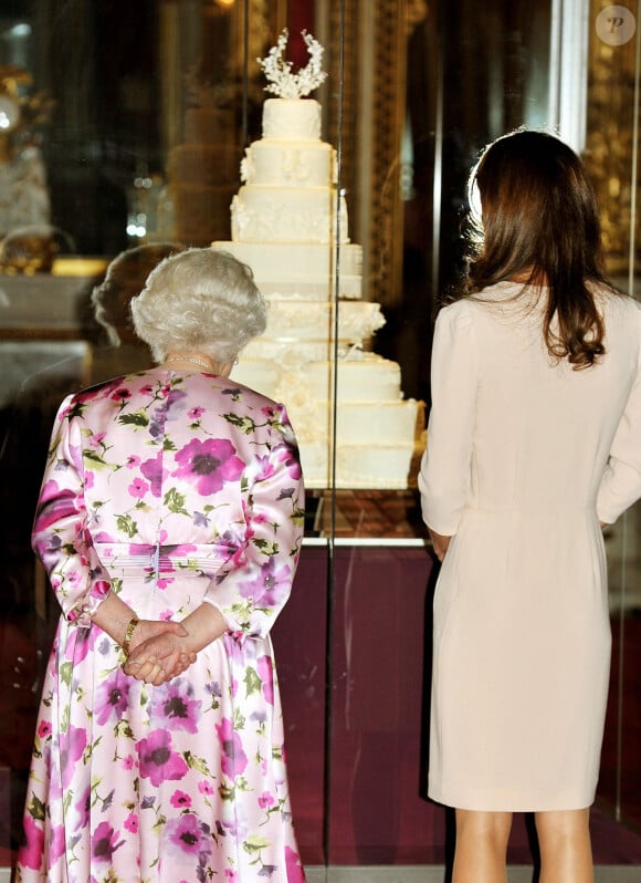 Kate Middleton devant la réplique de son gâteau de mariage avec la reine Elizabeth II, le 22 juin 2011 au palais de Buckingham.