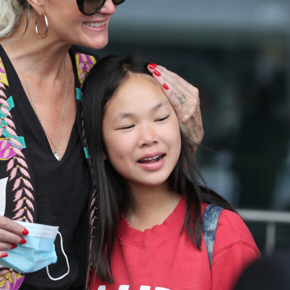 Laeticia Hallyday et ses filles Jade et Joy arrivent, avec des masques de protection contre l'épidémie de coronavirus (Covid-19), à l'aéroport de Paris-Charles-de-Gaulle à Roissy-en-France, France, le 18 juin 2020.