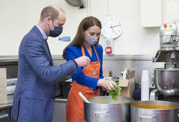Le prince William, duc de Cambridge et Catherine (Kate) Middleton, duchesse de Cambridge, aident à préparer des repas avec des représentants de Sikh Sanjog, qui seront distribués aux familles vulnérables, dans la cuisine du café du Palace de Holyroodhouse à Édimbourg, Ecosse, Royaume Uni, le 24 mai 2021.