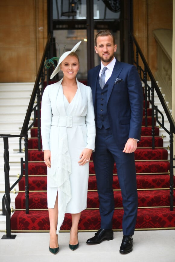 Le footballeur Harry Kane et sa femme Kate Kane posent devant le palais de Buckingham avant sa remise de médaille de l'ordre de l'empire britannique. Londres, le 28 mars 2019.