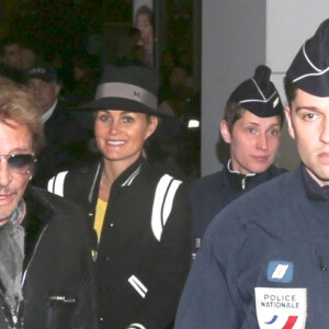 Johnny et Laeticia Hallyday arrivent à Paris avec leur chien Santos. Le 8 décembre 2013.