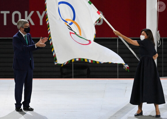 Anne Hidalgo, maire de Paris, reçoit le drapeau olympique des mains de la gouverneure de Tokyo Yuriko Koike et par l'intermédiaire du président du CIO Thomas Bach, lors de la cérémonie de clôture des Jeux Olympiques de Tokyo.