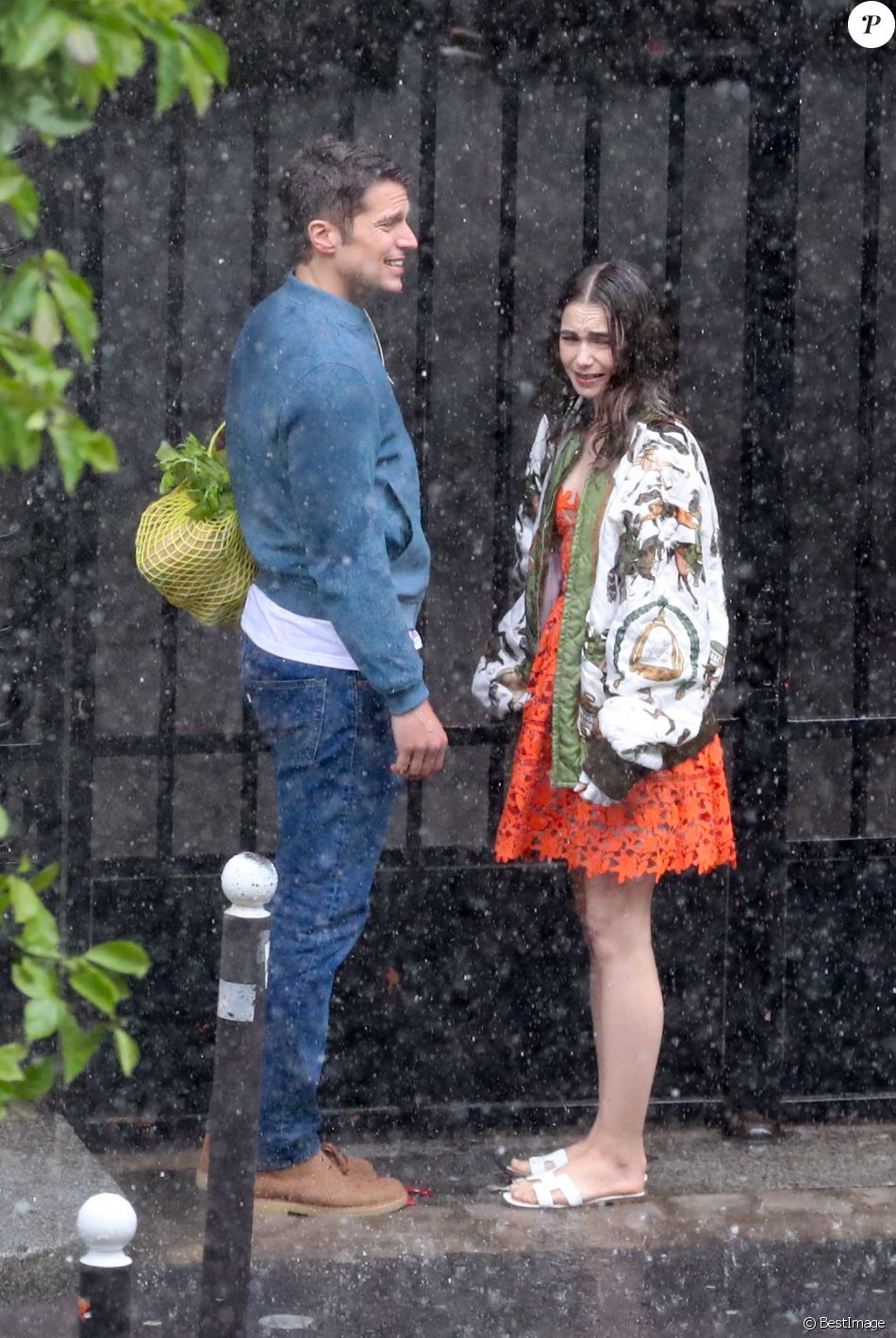 Lily Collins et Lucas Bravo tournent une scène romantique sous la pluie dans les rues de Paris, pour la saison 2 de la série &quot;Emily in Paris&quot;. Le 19 mai 2021.