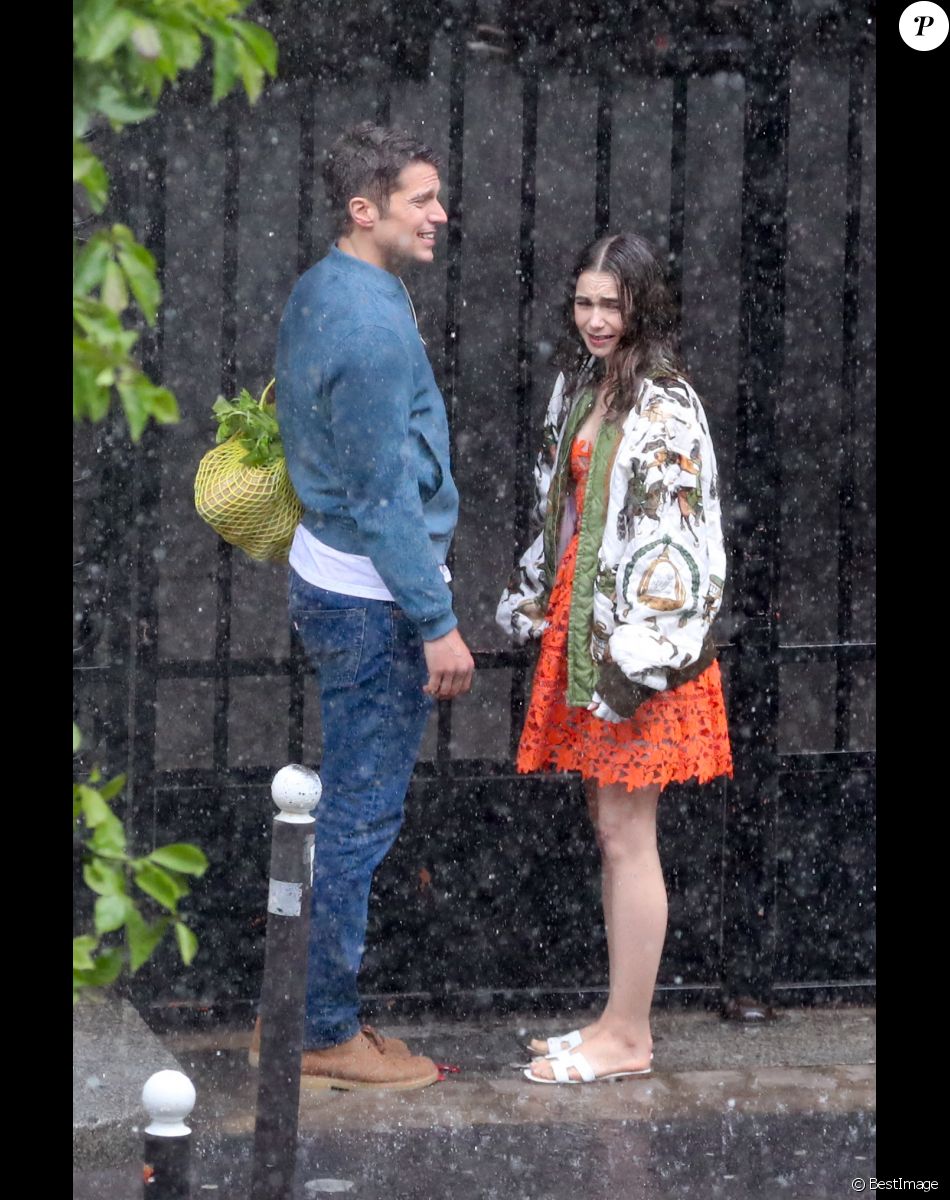 Lily Collins et Lucas Bravo tournent une scène romantique sous la pluie dans les rues de Paris, pour la saison 2 de la série "Emily in Paris". Le 19 mai 2021.