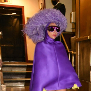Lady Gaga en total look violet et coiffe en plumes d'autruche à la sortie du Radio City Music Hall à New York, le 31 juillet 2021.
