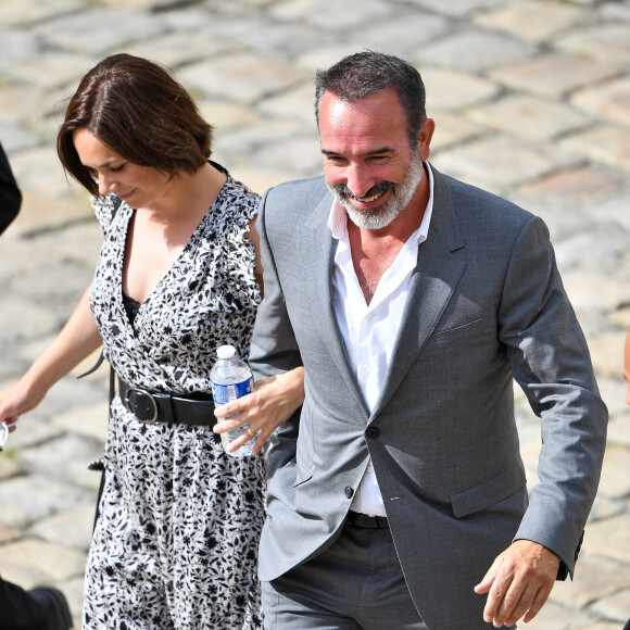 Jean Dujardin, souriant et sa femme Nathalie Péchalat arrive aux Invalides pour l'hommage national à Jean-Paul Belmondo. 