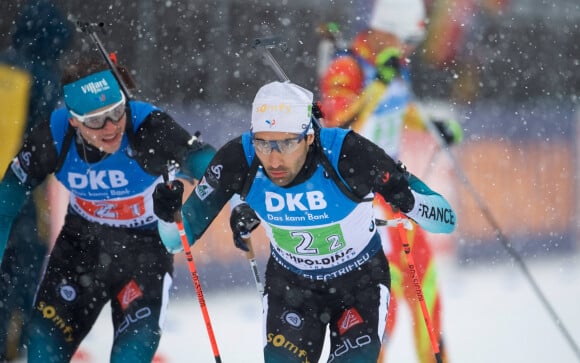 Emilien Jacquelin passant le relais à Martin Fourcade lors du relais de biathlon à Ruhpolding en Allemagne le 18 janvier 2020.