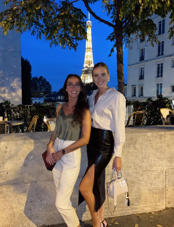 Amandine Petit et sa grande soeur posent devant une Tour Eiffel illuminée sur l'Avenue du Président Wilson, dans le 16e arrondissement de Paris. Le 14 septembre 2021.