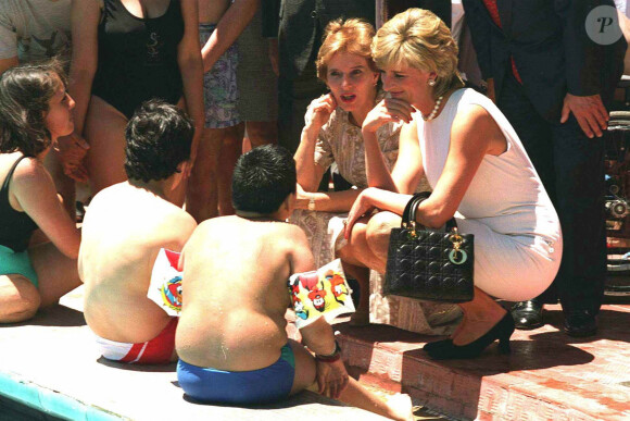 Diana en voyage en Argentine en 1995, avec son sac à main Lady Dior. 