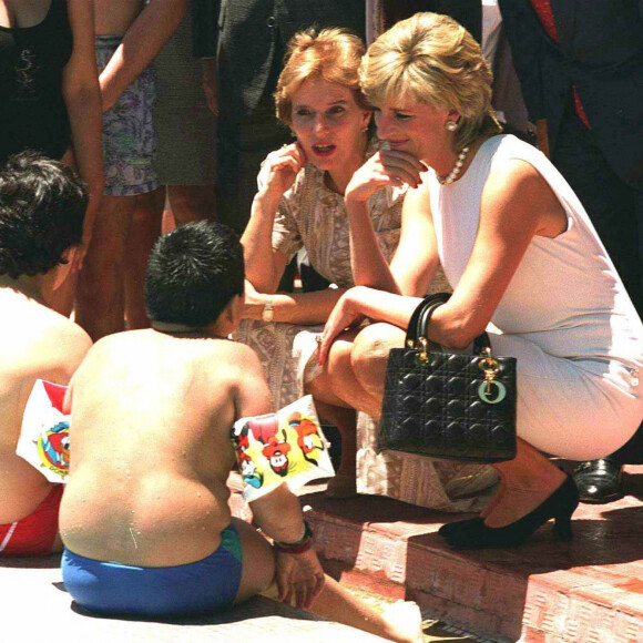 Diana en voyage en Argentine en 1995, avec son sac à main Lady Dior. 