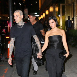 Travis Barker et sa compagne Kourtney Kardashian quittent le "Polo Bar" pour se rendre à la représentation de la pièce "Hadestown" à Broadway à New York, le 15 octobre 2021.