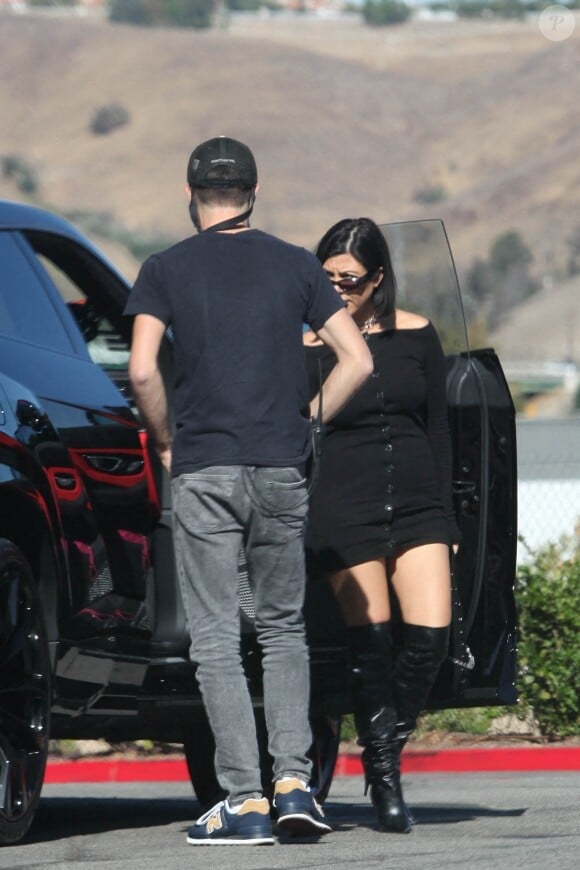 Exclusif - Kourtney Kardashian et son compagnon Travis Barker sont passés chez Erewhon Market à Calabasas le 12 octobre 2021. Kourtney porte une minirobe noire et des cuissardes en cuir noir.