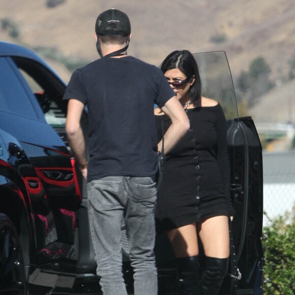 Exclusif - Kourtney Kardashian et son compagnon Travis Barker sont passés chez Erewhon Market à Calabasas le 12 octobre 2021. Kourtney porte une minirobe noire et des cuissardes en cuir noir.