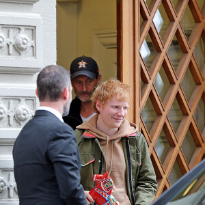 Ed Sheeran, avec un cadeau en main, quitte son hôtel à Stockholm, le 6 octobre 2021.