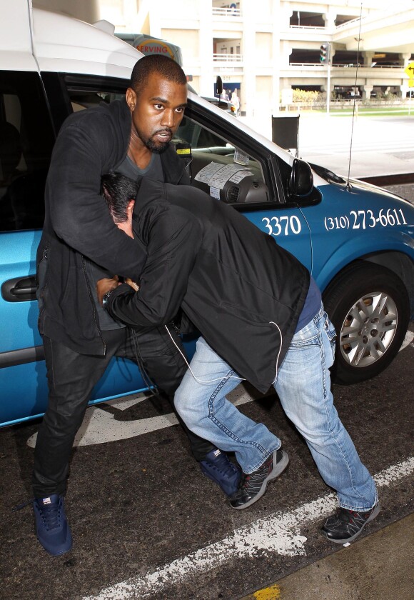 Kanye West et le paparazzi Daniel Ramos à l'aéroport LAX. Los Angeles, le 19 juillet 2013.