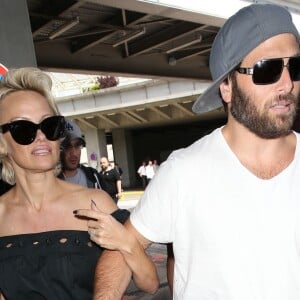 Pamela Anderson arrive avec son mari Rick Salomon à l'aéroport de Nice pour le festival de Cannes, le 13 mai 2014.