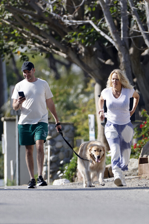 Pamela Anderson ne porte plus son alliance lors d'une balade avec son chien à Malibu le 14 janvier 2022. Elle semble soucieuse et a confié la laisse à son assistant. 