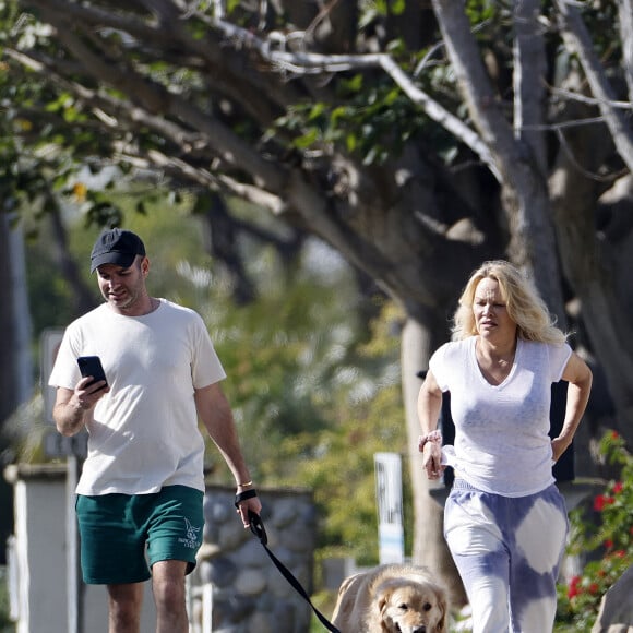 Pamela Anderson ne porte plus son alliance lors d'une balade avec son chien à Malibu le 14 janvier 2022. Elle semble soucieuse et a confié la laisse à son assistant. 