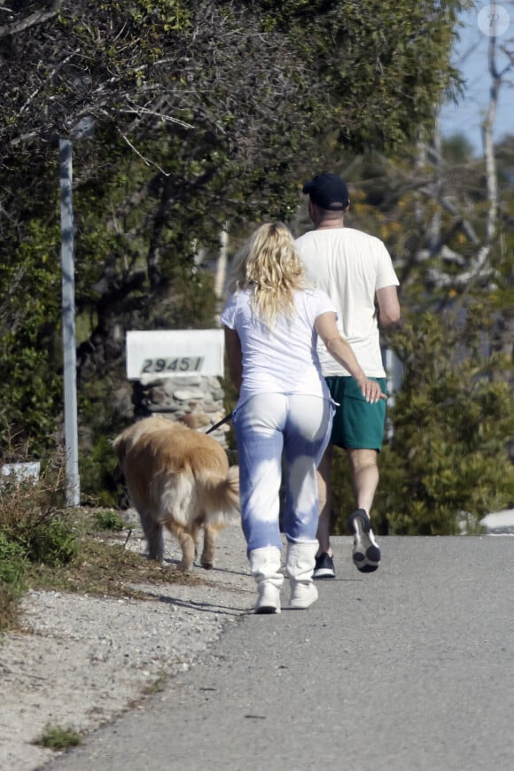 Pamela Anderson ne porte plus son alliance lors d'une balade avec son chien à Malibu le 14 janvier 2022. Elle semble soucieuse et a confié la laisse à son assistant. 