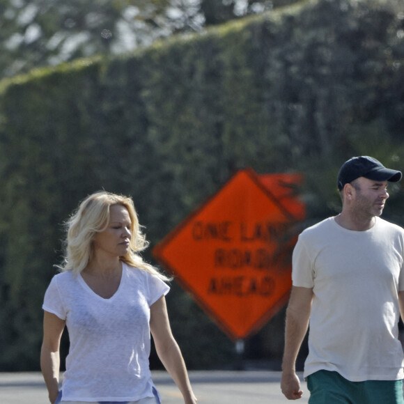 Pamela Anderson ne porte plus son alliance lors d'une balade avec son chien à Malibu le 14 janvier 2022. Elle semble soucieuse et a confié la laisse à son assistant. 