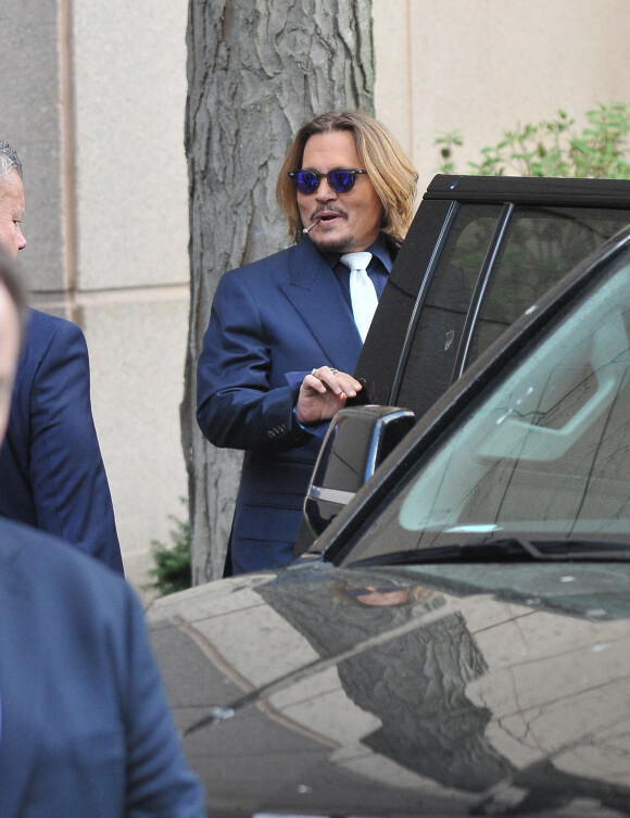 Johnny Depp et ses avocats sortent de leur hôtel à McLean, Virginie, Etats-Unis, le 12 avril 2022, pour se rendre au tribunal pour le deuxième jour du procès en diffamation. Johnny Depp en profite pour saluer ses fans avant de monter dans sa voiture. 