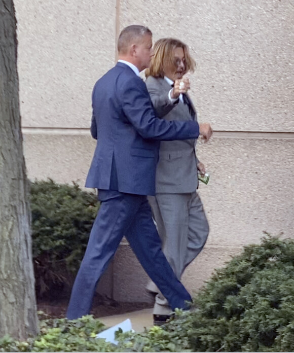 Johnny Depp et Amber Heard sortent du tribunal après le premier jour de leur procès en diffamation à Fairfax le 11 avril 2022. 
