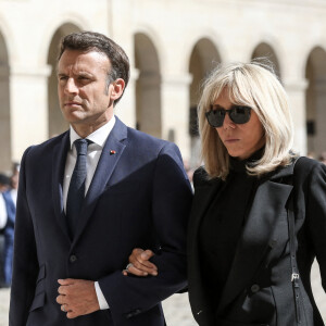 Le président français Emmanuel Macron, accompagné de la première dame Brigitte Macron, lors de l'hommage national à Françoise Rudetzki, grande représentante des victimes des attentats, dans la cour d'honneur de l'Hôtel national des Invalides à Paris