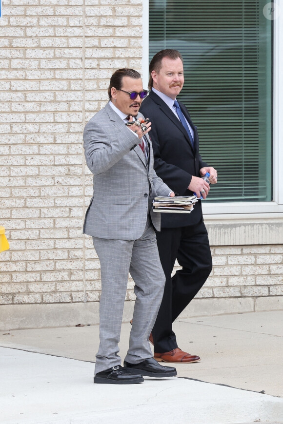 Johnny Depp retourne au tribunal après une pause cigarette lors du procès intenté contre son ex-femme, Amber Heard à Fairfax, Virginie, Etats-Unis, le 26 mai 2022. 