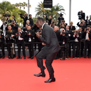 Omar Sy à la montée des marches de "Top Gun : Maverick" lors du 75ème Festival International du Film de Cannes, le 18 mai 2022. 