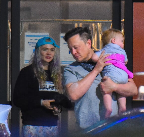 Elon Musk porte son fils X AE A-XII Musk à la sortie de l'Aéroport de Teterboro, New Jersey le 3 mai 2021. Sa compagne Grimes (Claire Boucher) est aussi du voyage.
