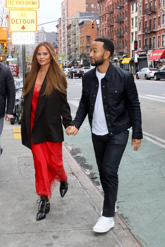 Chrissy Teigen et son mari John Legend se tiennent la main à la sortie de leur hôtel à New York City, New York, Etats-Unis, le 26 avril 2022. 