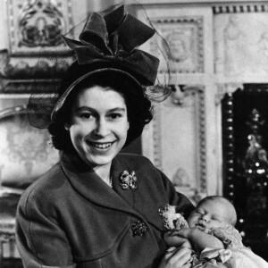 Archives - Rétrospective la reine Elisabeth II d'Angleterre - La princesse Elisabeth tient dans ses bras son fils, le prince Charles après son baptême à Buckingham Palace, le 14 décembre 1948