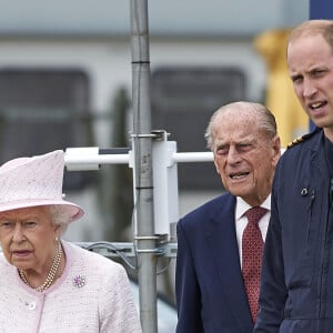 La reine Elisabeth II d'Angleterre et le prince Philip, duc d'Edimbourg visitent avec leur petit-fils prince William, duc de Cambridge, la nouvelle base East Anglian Air Ambulance à l'aéroport de Cambridge où il travaille à Cambridge, le 13 juillet 2016. 