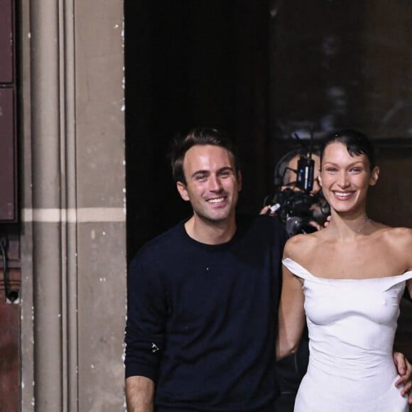 Bella Hadid arrive sur le podium vêtue d'une simple culotte, c'est alors que trois hommes pulvérise une solution sur le mannequin américain et en quelques minutes, une robe minimaliste à manches à épaules dénudées et fente latérale à été créée en clôture du défilé Coperni Collection Femme Prêt-à-porter Printemps/Eté 2023 lors de la Fashion Week de Paris (PWF), France, le 30 septembre 2022. 