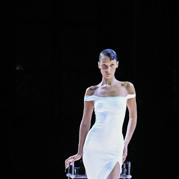 Bella Hadid arrive sur le podium vêtue d'une simple culotte, c'est alors que trois hommes pulvérise une solution sur le mannequin américain et en quelques minutes, une robe minimaliste à manches à épaules dénudées et fente latérale à été créée en clôture du défilé Coperni Collection Femme Prêt-à-porter Printemps/Eté 2023 lors de la Fashion Week de Paris (PWF), France, le 30 septembre 2022. 