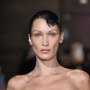 Bella Hadid arrive sur le podium vêtue d’une simple culotte, c'est alors que trois hommes pulvérise une solution sur le mannequin américain et en quelques minutes, une robe minimaliste à manches à épaules dénudées et fente latérale à été créée en clôture du défilé Coperni Collection Femme Prêt-à-porter Printemps/Eté 2023 lors de la Fashion Week de Paris (PWF), France, le 30 septembre 2022.  Performance of fashion model Bella Hadid during the Coperni Womenswear Spring/Summer 2023 show as part of Paris Fashion Week on September 30, 2022 in Paris, France. 