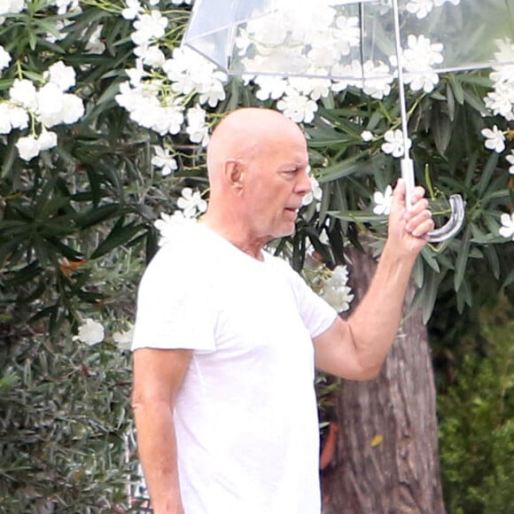 Bruce Willis se protège de la canicule avec un parapluie transparent à Los Angeles le 9 septembre 2022. 