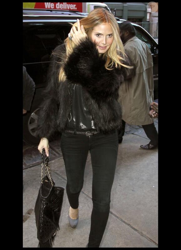 Heidi Klum chic en look city perchée sur ses Saint Laurent et à l'aise dans un slim noir et une blouse lamée Darel. 