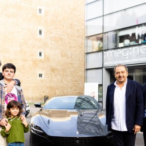 Remise, par Patrick Timsit et Arnold Munnich (Président de la Fondation Imagine), de la Ferrari Roma à Philippe R. l'heureux gagnant de la tombola "Le Grand Prix Imagine" avec le ticket n° 461 678 43, entouré de sa famille, à l'Institut Imagine à Paris. Le 29 octobre 2022. © Tiziano da Silva / Bestimage