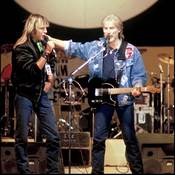 Archives - Le chanteur Renaud et Hugues Aufray sur scène pour "Chanteurs sans frontières" en 1985.