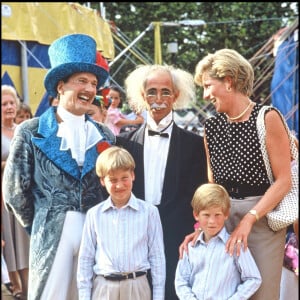 Mais ils souffrent toujours autant de la mort de leur mère, il y a 25 ans. 
Lady Diana, le prince William et le prince Harry avec des clowns devant un cirque en 1990.