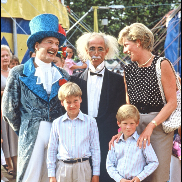 Mais ils souffrent toujours autant de la mort de leur mère, il y a 25 ans. 
Lady Diana, le prince William et le prince Harry avec des clowns devant un cirque en 1990.