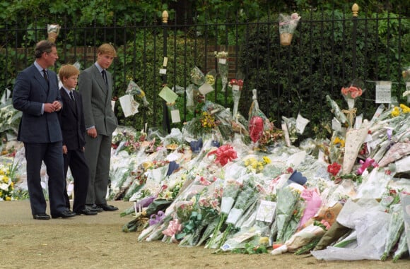 Le prince Charles, prince de Galles, Le prince Harry, duc de Sussex, prince William, duc de Cambridge devant les fleurs déposées pour Lady Diana en septembre 1997. 