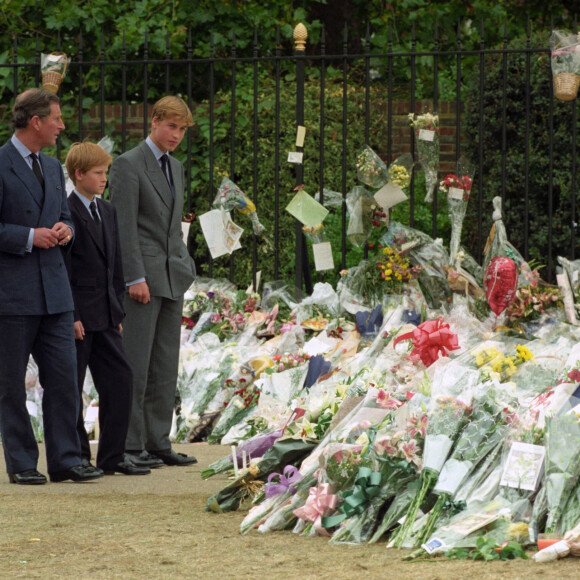Le prince Charles, prince de Galles, Le prince Harry, duc de Sussex, prince William, duc de Cambridge devant les fleurs déposées pour Lady Diana en septembre 1997. 