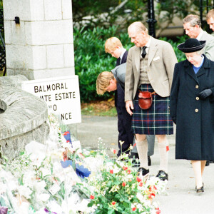 La reine Elisabeth II d'Angleterre et le prince Philip, duc d'Edimbourg, le prince Charles et ses fils le prince William et le prince Harry, devant l'entrée du château de Balmoral, où de nombreux hommages ont été rendues suite à la mort de la princesse Diana. Le 5 septembre 1997 
